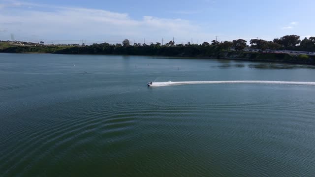 Low aerial view of the country inland, boats and the bay in Carlsbad, with boats out.