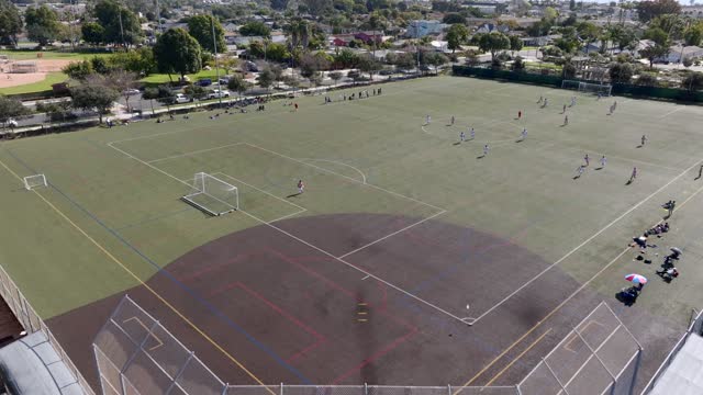 Aerial view of a park, homes and traffic in Carlsbad, with swimmers in the water.
