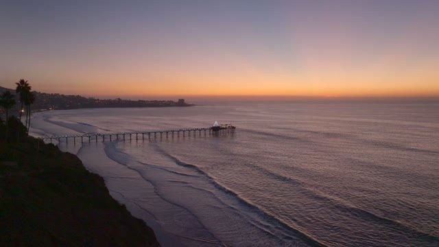 Aerial view of the cliffs, the pier and palm trees at La Jolla Shores.