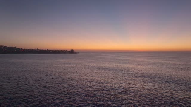 Low aerial view of the beach, the ocean and the cliffs at La Jolla Shores.