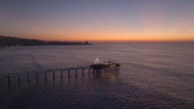 Low aerial view of the beach, the pier and the ocean at La Jolla Shores.