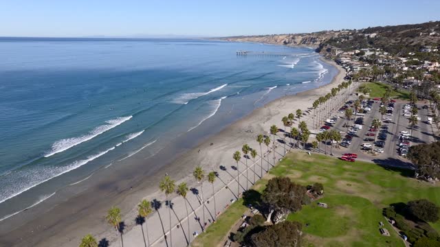 Aerial view of the beach, the surf and the pier at La Jolla Shores, with people walking.