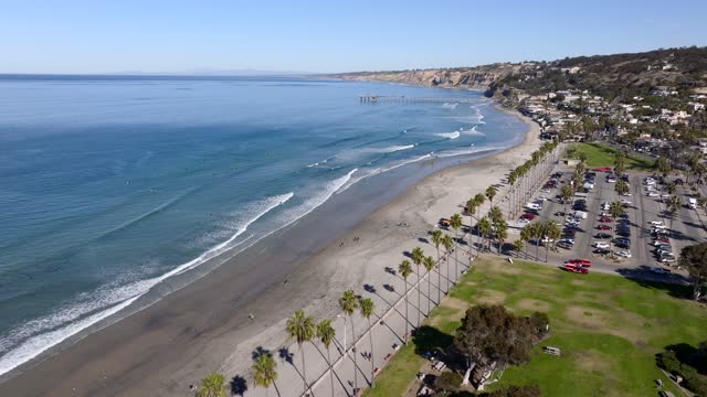 Aerial view of the beach, the surf and the pier at La Jolla Shores, with people walking.