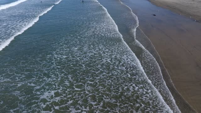 Low aerial view of the beach, the surf and the ocean at La Jolla Shores.