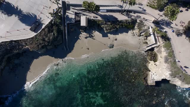 Aerial view of the beach, the ocean and the cliffs at La Jolla Cove.