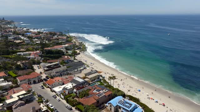Aerial view of the beach, the surf and palm trees at Beach Barber Tract, with people walking.