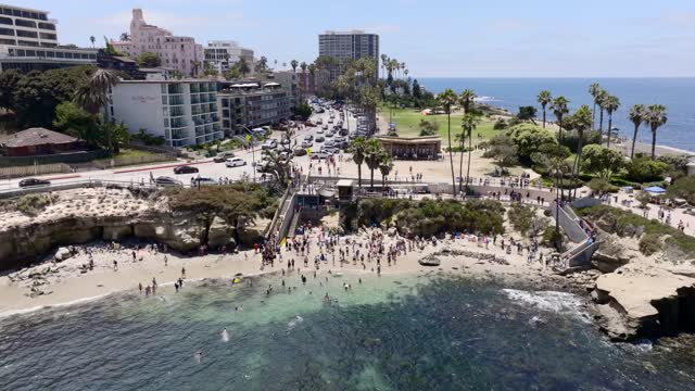 Aerial footage of people gathering with the Seals and Sea Lions at La Jolla Cove | Drone Video – 1
