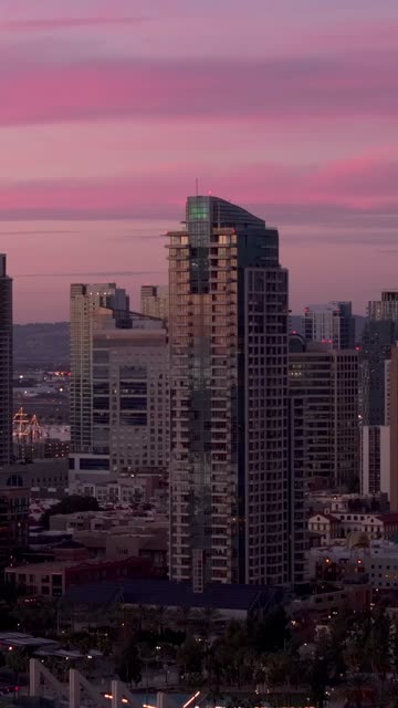 Aerial view of the Pinnacle Marina Tower in the Marina District downtown San Diego during sunset | Vertical Drone Video – 1