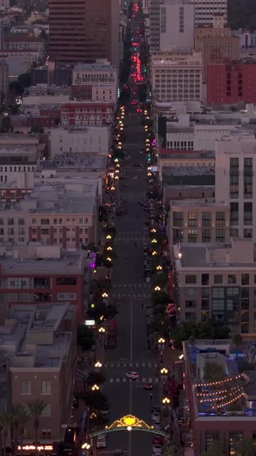 Aerial view of the Gaslamp sign and 5th Ave in the Gaslamp District of downtown San Diego during sunset | Vertical Drone Video