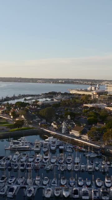 Aerial view of the USS Midway and Marina District of downtown San Diego during golden hour | Vertical Drone Video