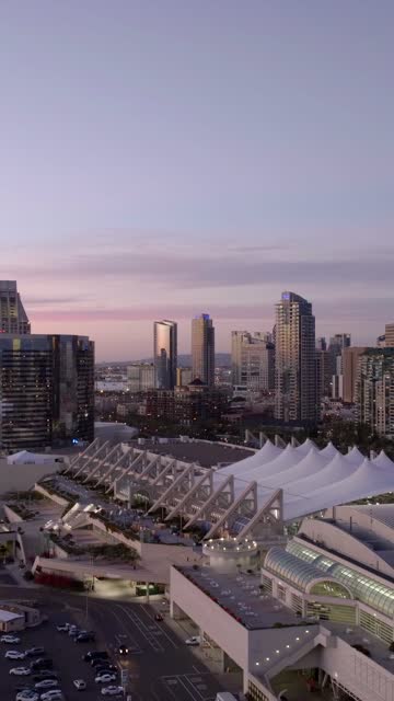 Aerial view of the San Diego skyline, convention center, and Marriott Marquis in the Marina District of downtown San Diego during sunset | Vertical Drone Video