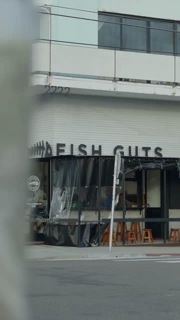 The downtown streets, the buildings and the city in Barrio Logan, with people eating outside.