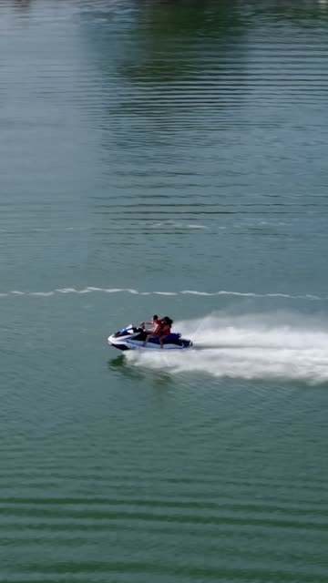 Low aerial view of the country inland, boats and traffic in Carlsbad, with boats out.