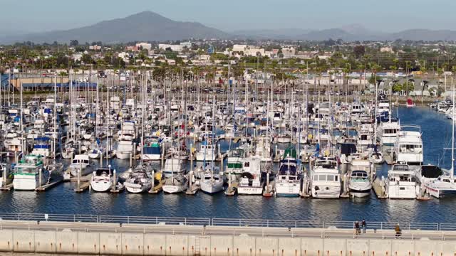 Low aerial view of the harbor, boats and palm trees in Chula Vista, with boats out.