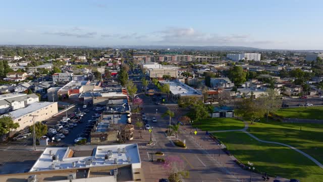 Low aerial view of the downtown streets, homes and the buildings in Chula Vista, with people walking.