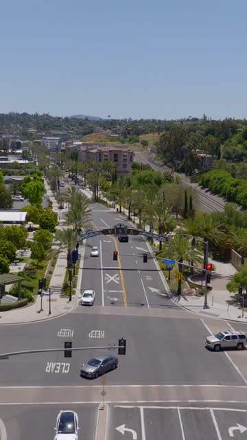 Low aerial view of the downtown streets, palm trees and the buildings in Vista.