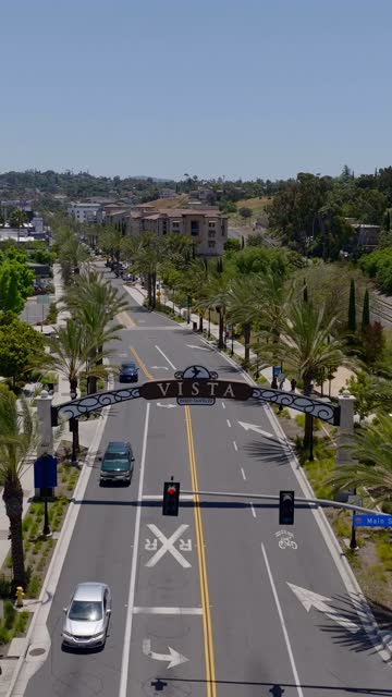 Low aerial view of the downtown streets, palm trees and the buildings in Vista.
