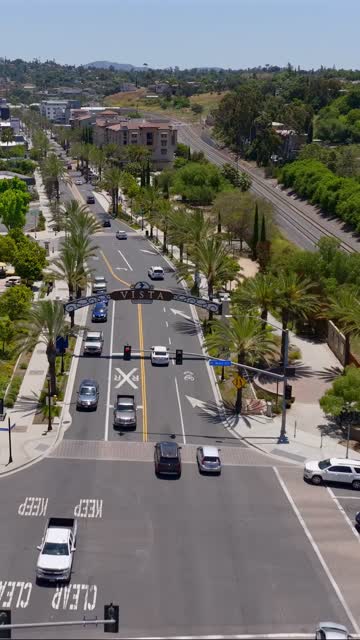 Low aerial view of the downtown streets, palm trees and the buildings in Vista.
