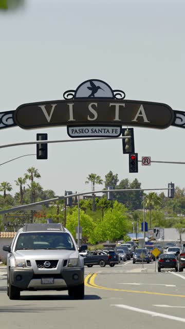 Walking view of the Vista sign with nearby shops, restaurants and the energetic downtown scene | Vertical Video – 4