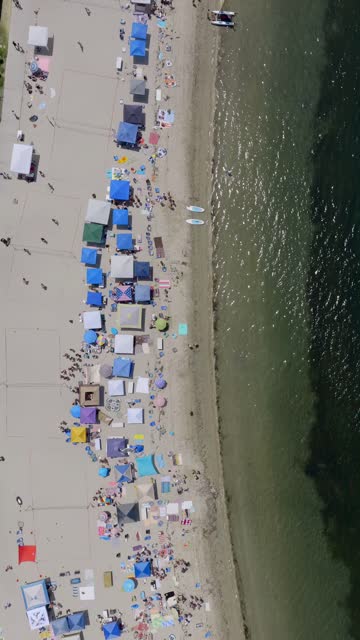 Aerial view of the beach, the bay and the water in Mission Bay, with a crowd gathered.