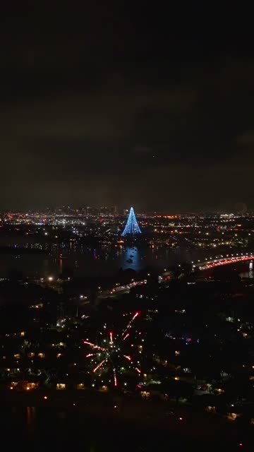 Aerial view of the country inland, the bridge and the bay in Mission Bay, with a crowd gathered.