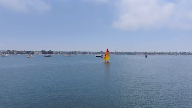 Low aerial view of the beach, boats and the bay in Mission Bay, with boats out.