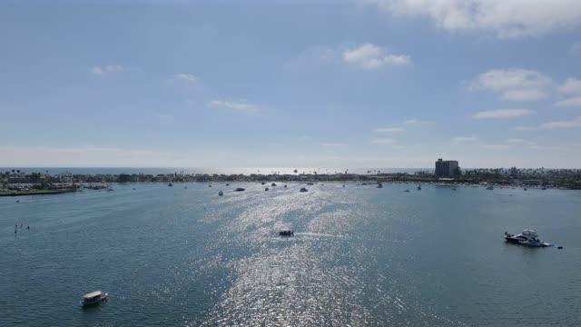 Low aerial view of the beach, boats and the bay in Mission Bay, with boats out.