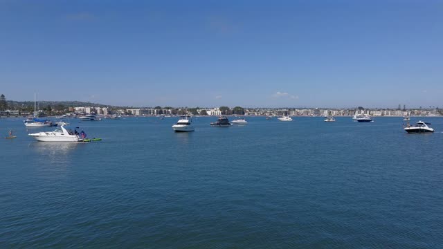 Low aerial view of the beach, boats and the bay in Mission Bay, with boats out.