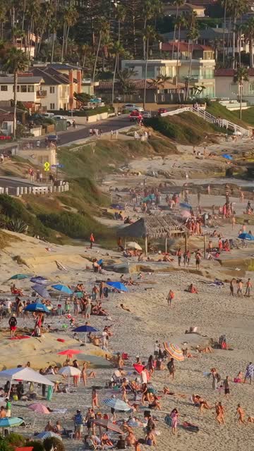 Beautiful afternoon at Windansea Beach in La Jolla with crowds enjoying the sun and beach activities at one of the most iconic beaches in San Diego | Vertical Drone Video – 1