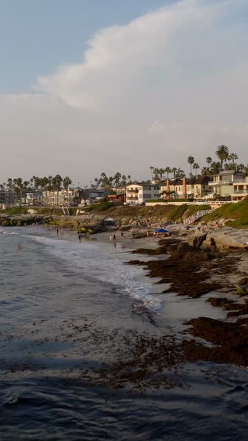 Beautiful afternoon at Windansea Beach in La Jolla with crowds enjoying the sun and beach activities at one of the most iconic beaches in San Diego | Vertical Drone Video – 3