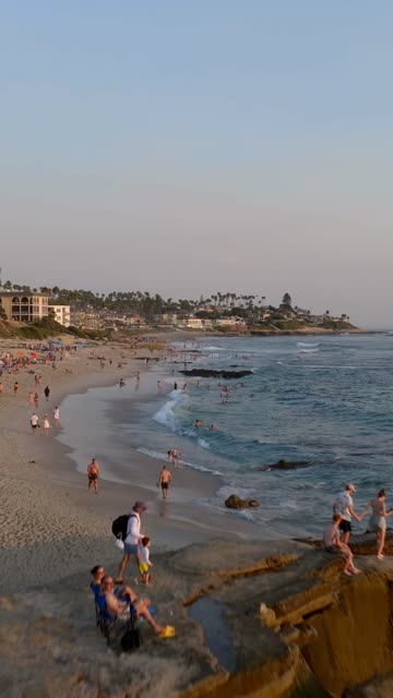 Beautiful afternoon at Windansea Beach in La Jolla with crowds enjoying the sun and beach activities at one of the most iconic beaches in San Diego | Vertical Drone Video – 8