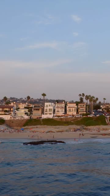 The beach, palm trees and the ocean at Beach Barber Tract, with people walking.