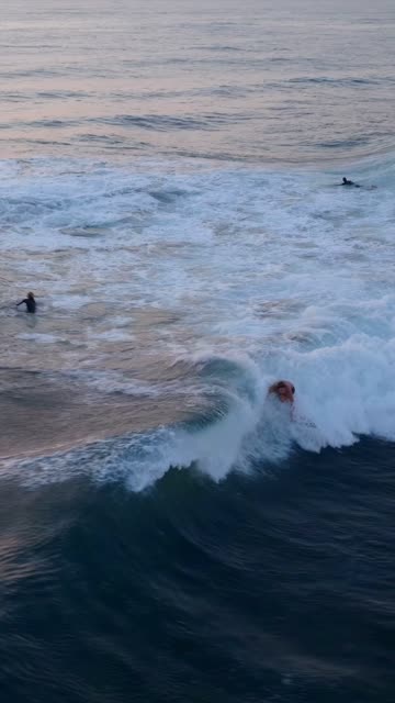 Low aerial view of the beach, the surf and the ocean at Beach Barber Tract, with surfers out.