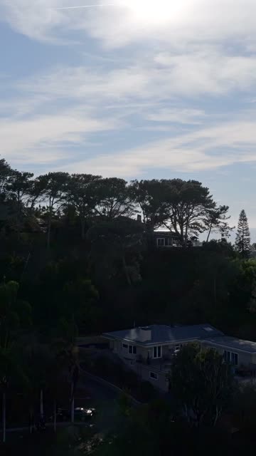 Low aerial view of a residential street, homes and traffic in Del Mar.