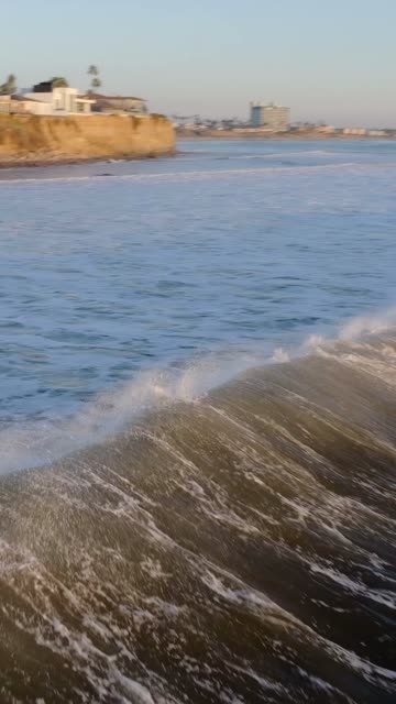 Low aerial view of the beach, the surf and the ocean at Bird Rock.