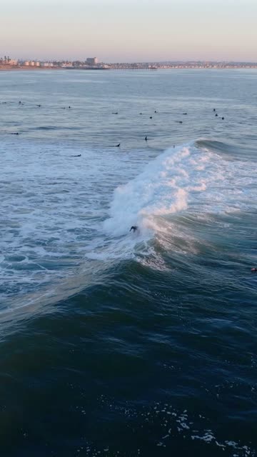 Low aerial view of the beach, the surf and the ocean at Bird Rock, with surfers out.
