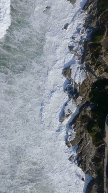 Aerial view of the cliffs, the surf and the ocean at Beach Barber Tract.