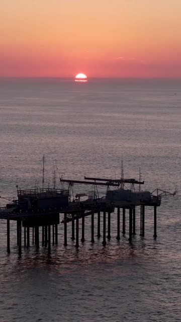 Low aerial view of the beach, the pier and the ocean at Black’s Beach.
