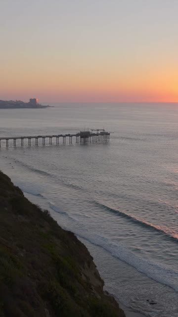 Aerial view of the cliffs, the surf and the pier at Black’s Beach.