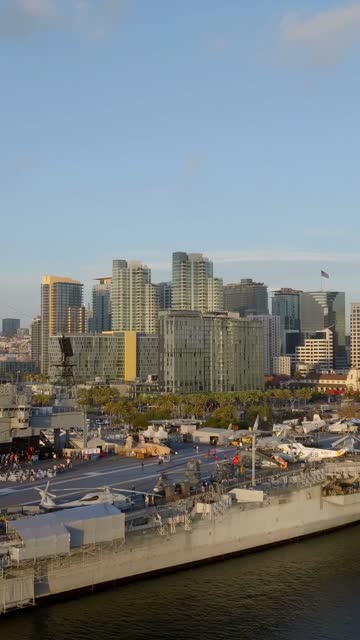 Low aerial view of the harbor, the skyline and boats at Embarcadero, with a work crew on site.