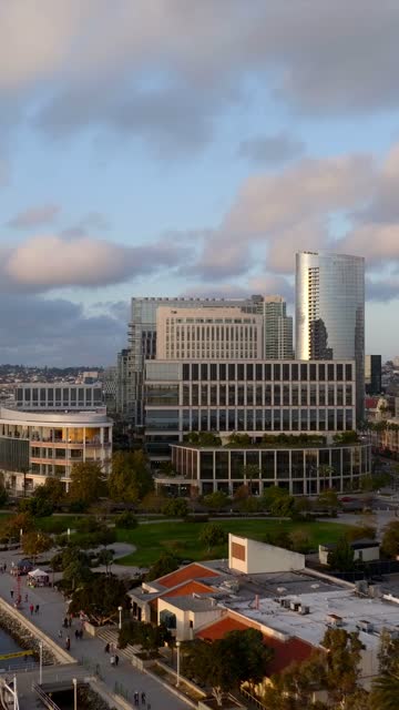 Low aerial view of the downtown streets, the skyline and palm trees at Embarcadero, with people walking.