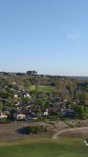 Aerial view of a residential street, homes and open country in Santaluz.