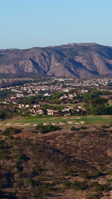 Aerial view of a residential street, homes and open country in Santaluz.