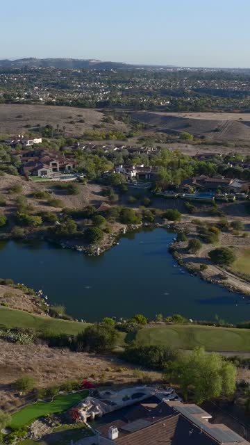 Aerial view of a residential street, homes and open country in Santaluz.