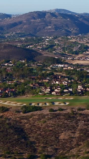 Aerial view of a residential street, homes and open country in Santaluz.