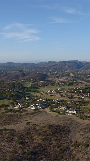 Aerial view of a residential street, homes and open country in Santaluz.