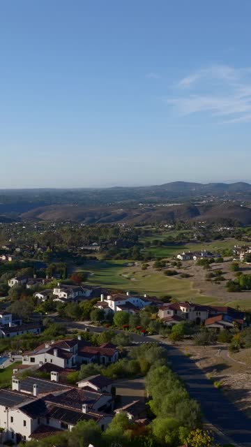 Aerial view of a residential street, homes and open country in Santaluz.