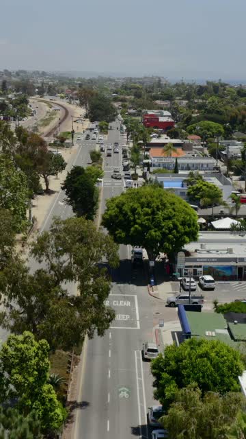 Low aerial view of the downtown streets, palm trees and homes in Encinitas.