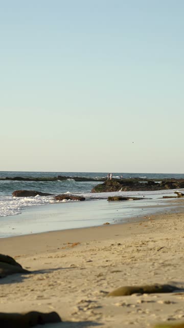 The beach, the surf and the ocean at Beach Barber Tract, with people walking.