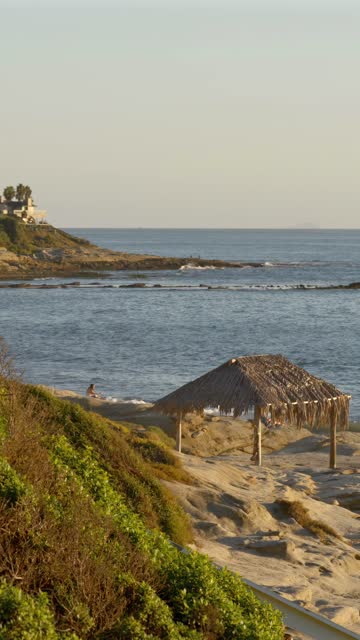 Elevated view of the beach, the ocean and the cliffs at Beach Barber Tract, with people walking.